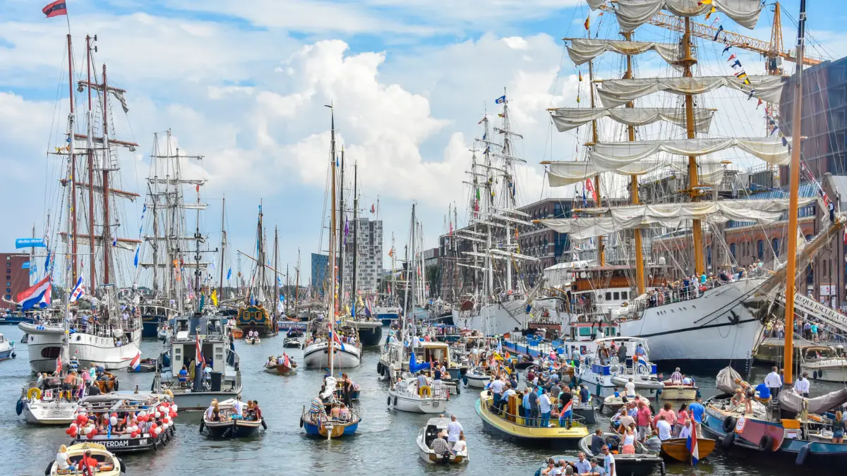 Harbor filled with boats and tall ships during SAIL Amsterdam festival