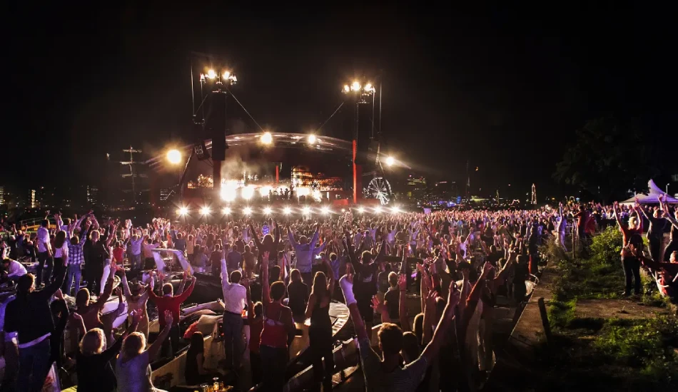 Nighttime concert with a large crowd cheering at Sail Amsterdam festival.