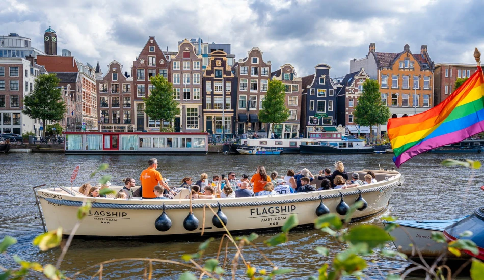 Group of people relaxing with drinks during a boat ride in Amsterdam.