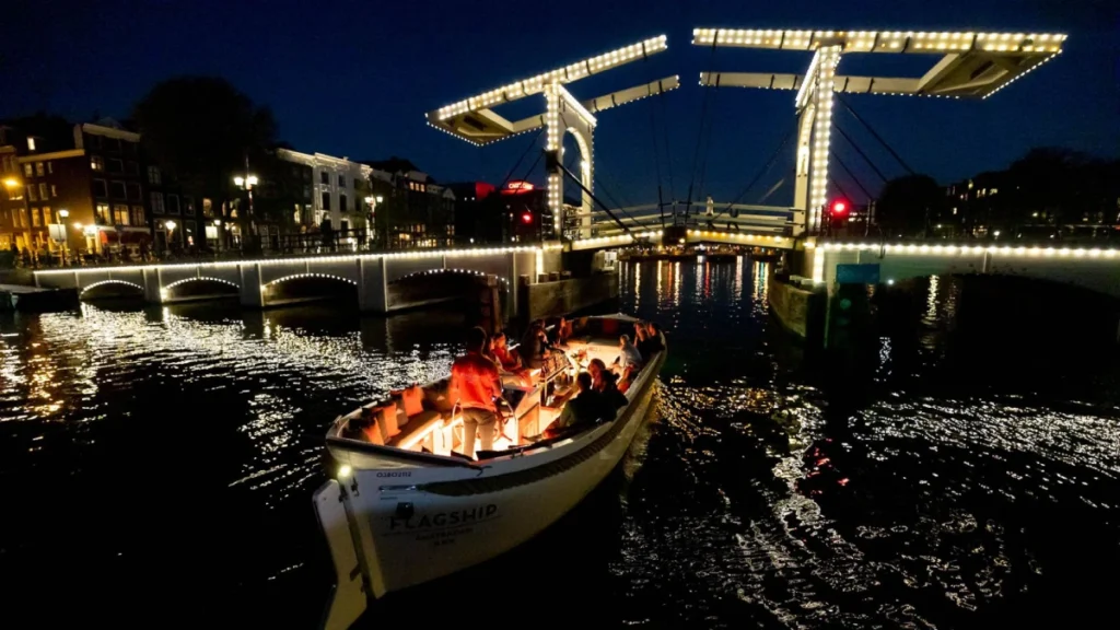 A canal boat ride in the evening with lighted background.
