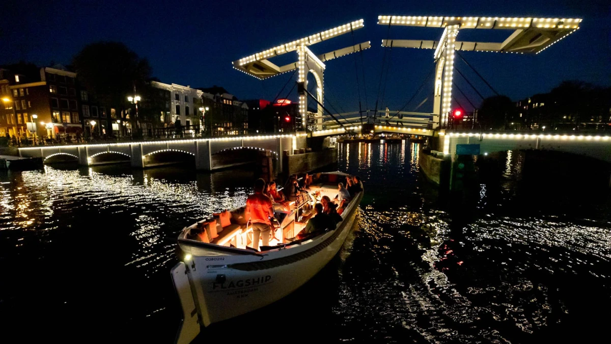 A canal boat ride in the evening with lighted background.