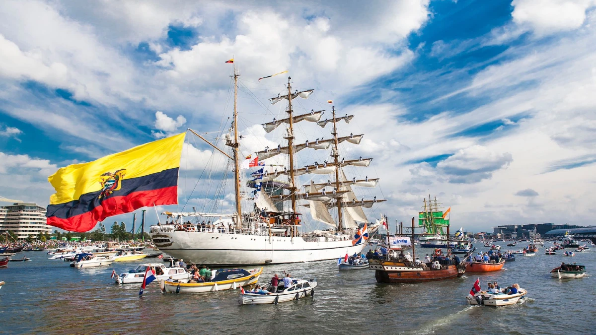 Large sailing vessel surrounded by boats at a maritime festival.