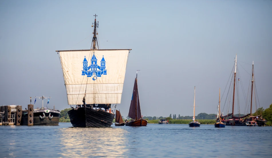 Traditional wooden ship with square sail among other classic sailboats