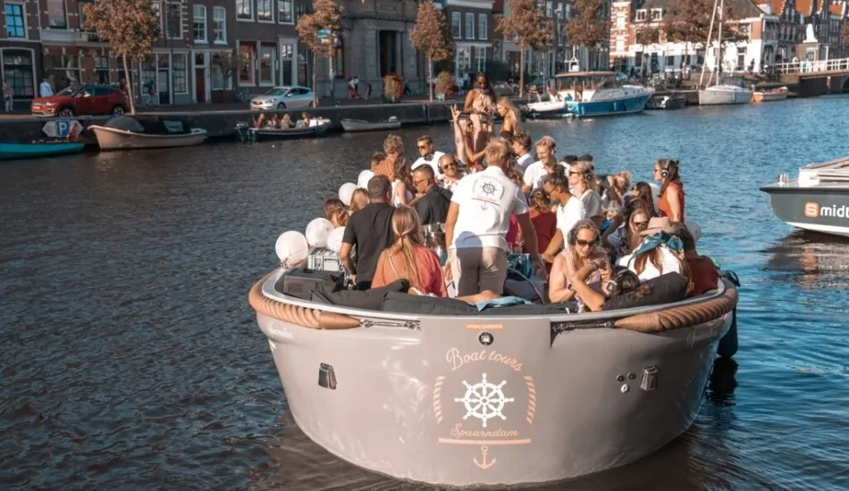 people sitting on a round boat to watch Sail Amsterdam parade.
