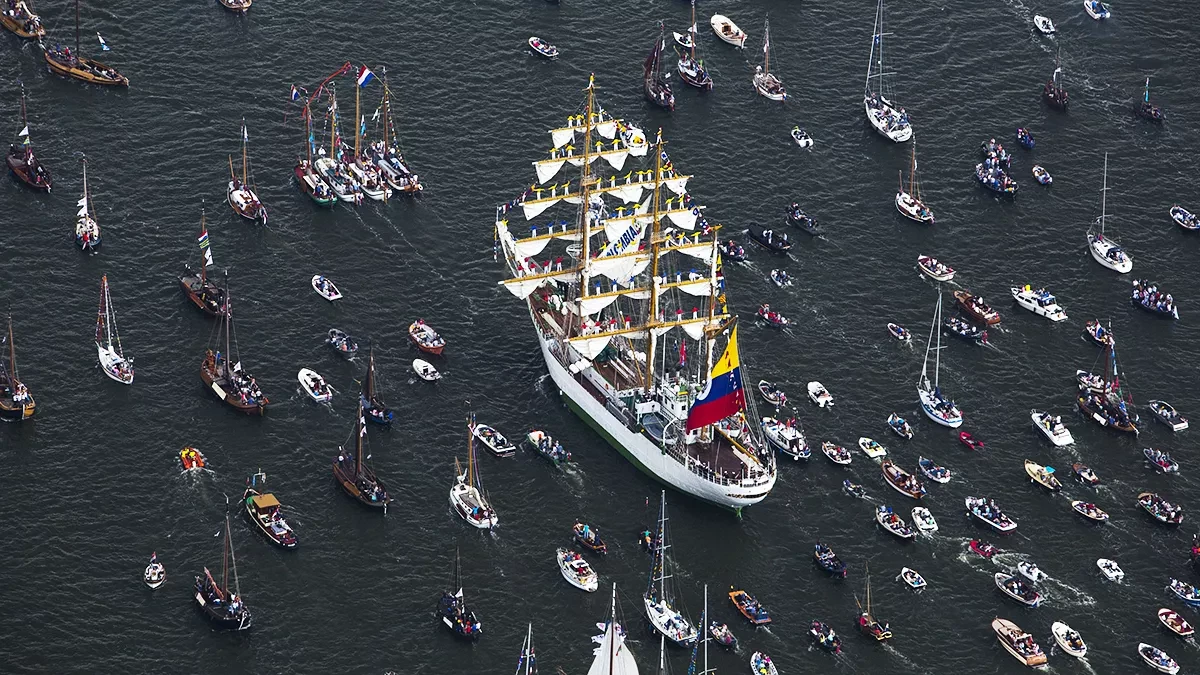 Aerial view of a tall ship surrounded by boats at Sail Amsterdam.