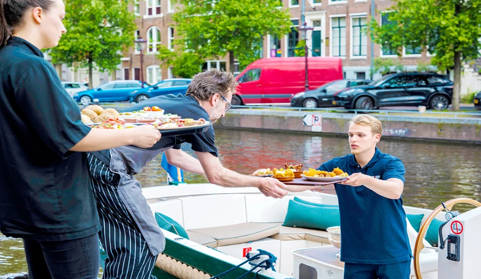 A server hands over trays of food from a boat to a customer.
