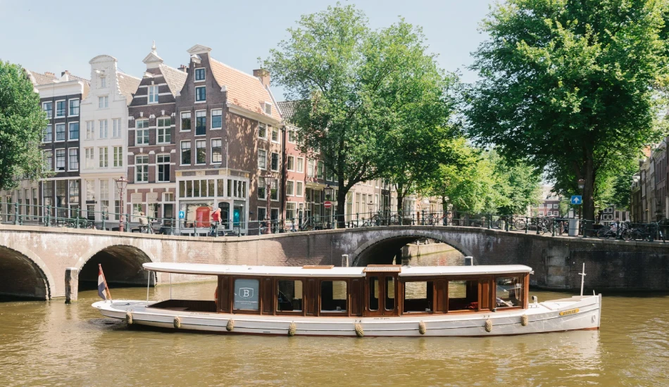 A wooden saloon boat sailing through a canal.